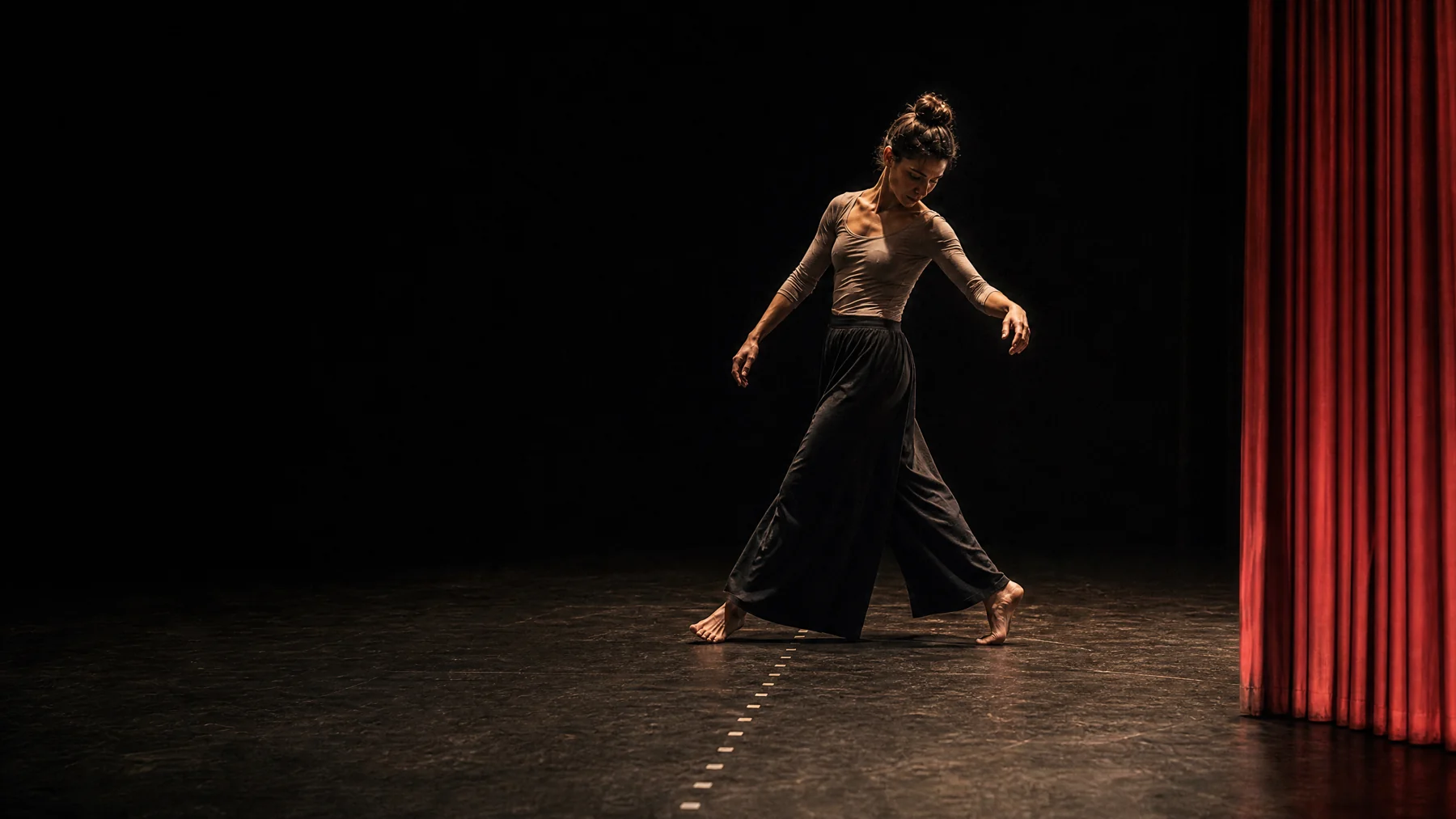 Performer moving across taped theatre stage